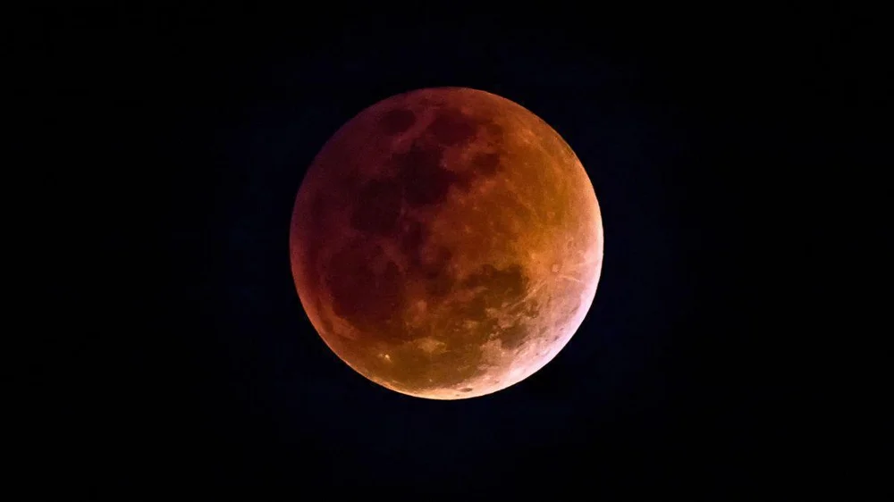 La matinada regala un espectacle astronòmic amb una lluna tenyida de roig abans de l'alba